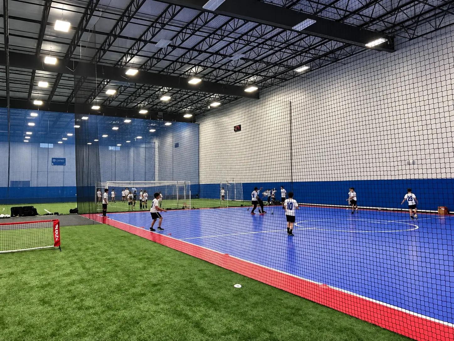 Youth soccer players training on Cadence's blue futsal court